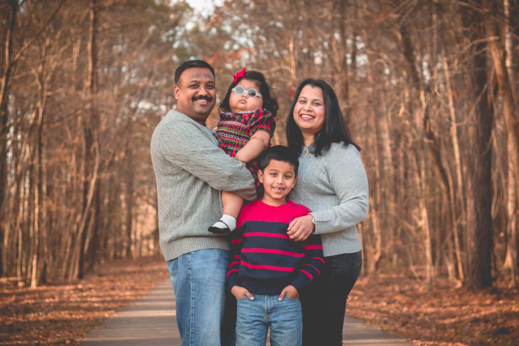 4 members of the Krishnan family posing in the woods