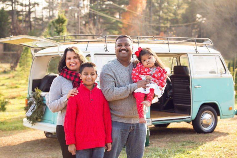 4 members of the Krishnan family posing in front of a VW bus